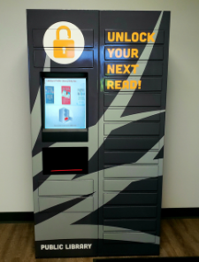 Photo of gray library book lockers with touchscreen device andtext "Unlock Your Next Read"