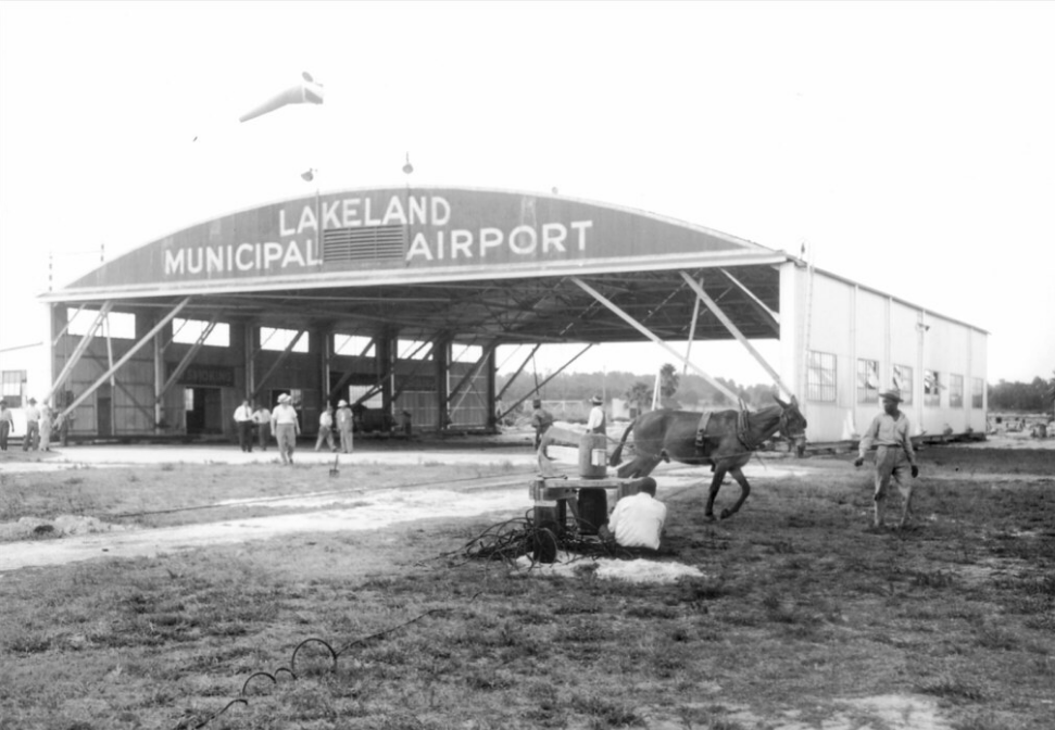 Work crews ready a hangar at the Lakeland Municipal Airport to be moved in 1940; link to Lakeland Public Library "Magnificent Flyers" Flickr album