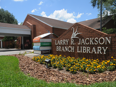 Larry R. Jackson Branch Library sign with books; link to Larry R. Jackson Branch Library page