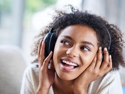 Girl listening to music on headphones; link to Music page