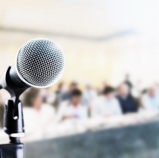 public meeting - close up of microphone with audience in background