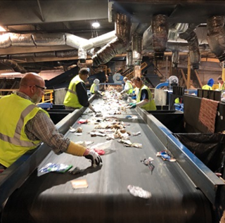 workers sorting recyclables on conveyor belt