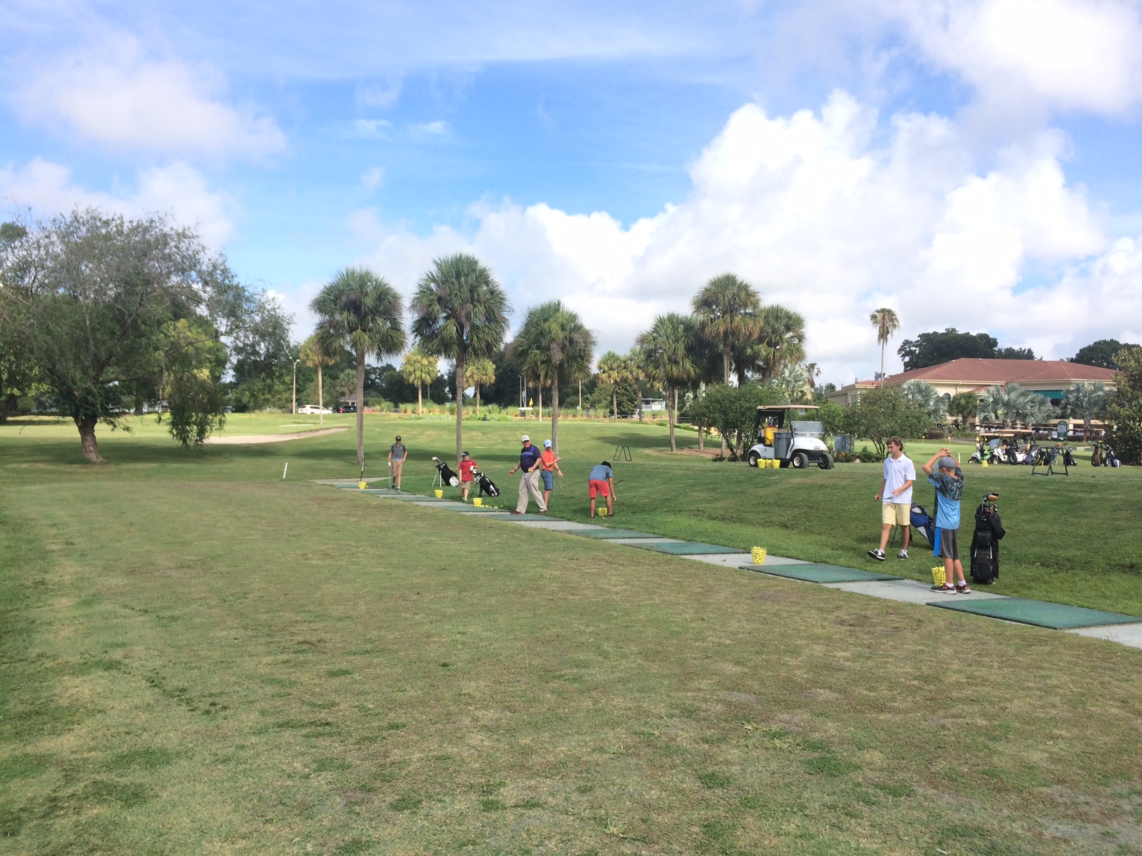 Junior Citrus League Golfers teeing off at Cleveland Heights Golf Course on a sunny day, with instructors