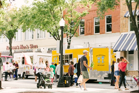 Food Trucks lined along street with families walking along sidewalk