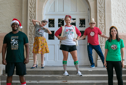 5 city staff wearing jingle bell jog shirts in front of City Hall