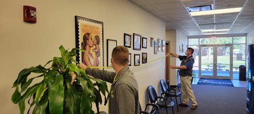 view of hallway with parks & rec employees measuring wallspace