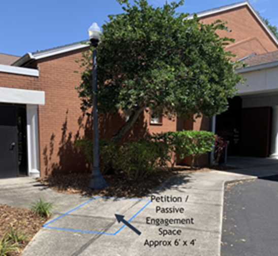 Petition space at Larry R. Jackson Branch outlined on sidewalk by parking lot, approximately 6' by 4' area where the main sidewalk joins the smaller sidewalk to the Meeting Room door.