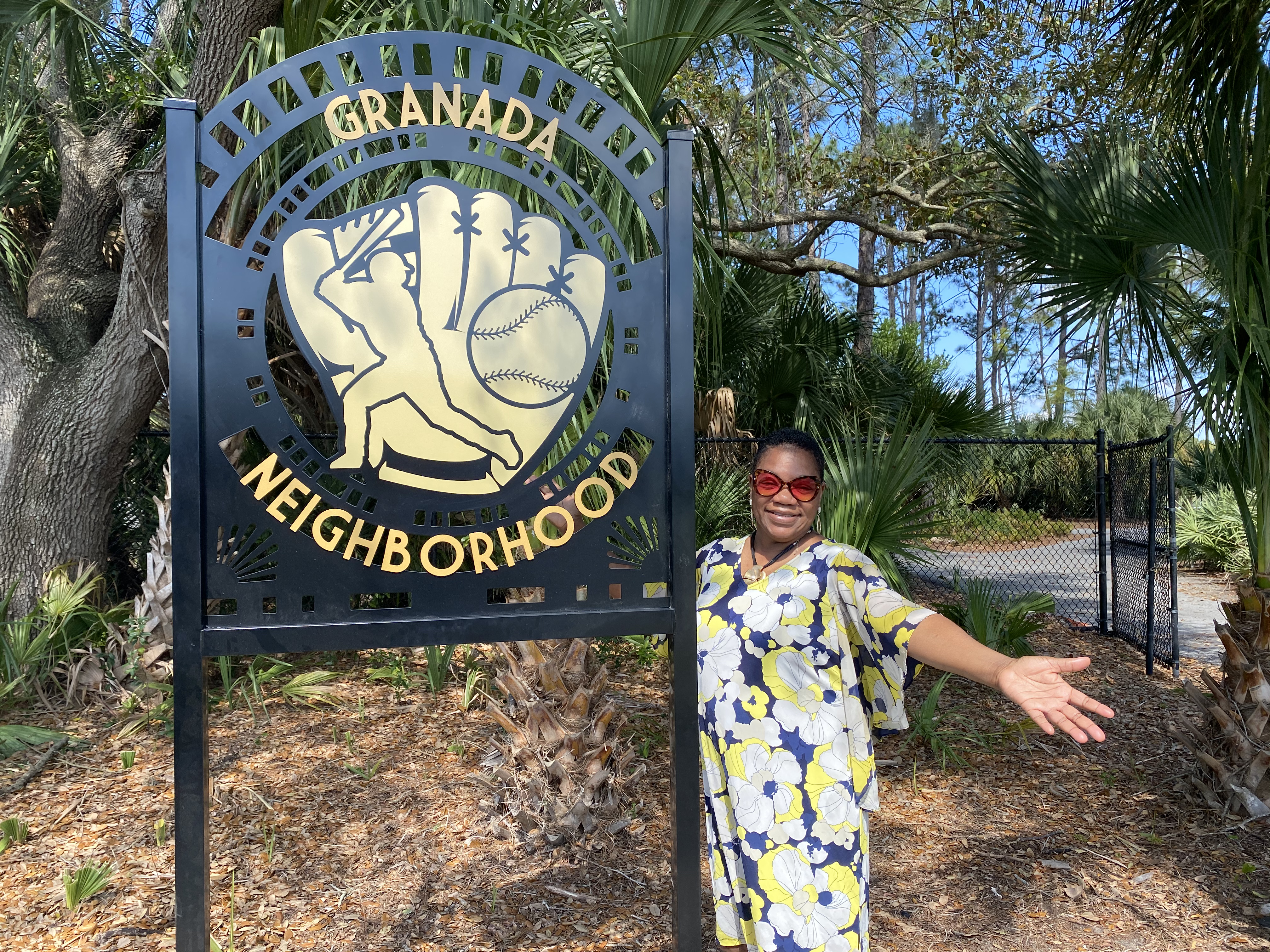 Neighborhood leader, Lynne Simpkins, stands with the Granada Neighborhood sign.