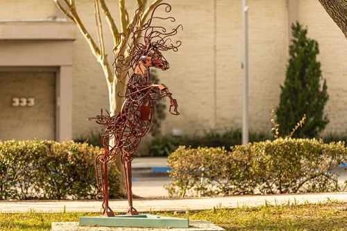 A red horse made of rods and wires reared on to it's hind legs