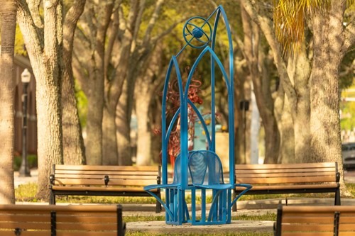 Four blue chairs sitting back-to-back underneath alternating heights of arches