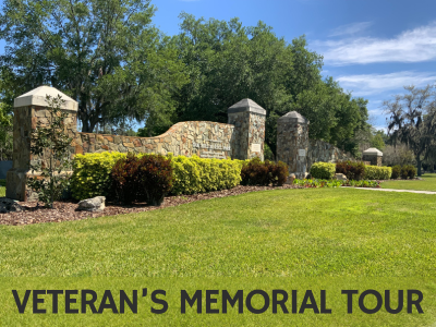 Stone wall entrance gate with grassy lawn and tall oak trees in the background at Oak Hill Burial Park with text Veteran's Memorial Tour; link to Lakeland Public Library "Veterans' Memorial Park" story map