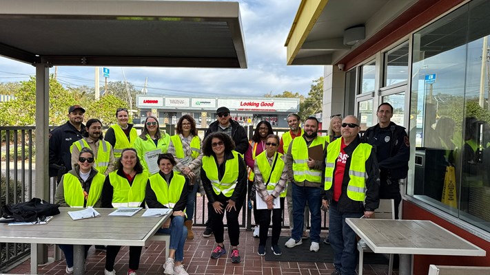 A group photo of people wearing bright yellow vests. They participated in the AARP Memorial Blvd Walk Audit.