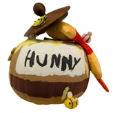 Craft pumpkin painted brown and white to look like a jar labeled Hunny. Attached are a brown lid, a yellow bumble bee, and a stuffed yellow bear with red shirt