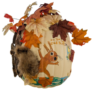 Craft pumpkin with a painted brown squirrel and attached leaves and fur tail