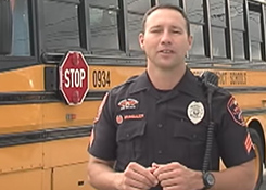 A police officer standing in front of a school bus