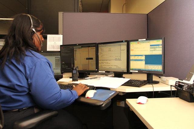 A picture of an employee working on a computer at the communications center