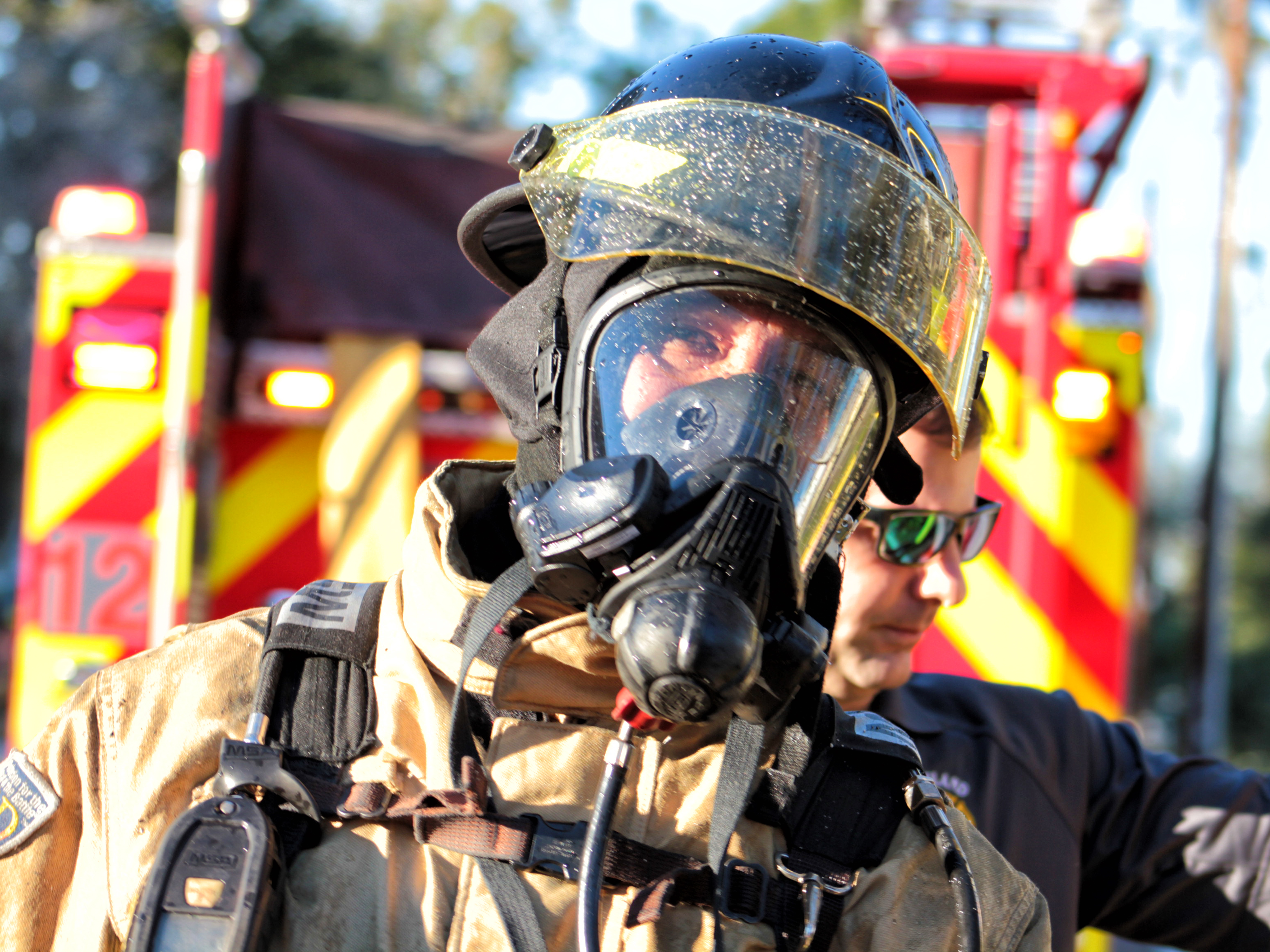 A picture of a firefighter on scene of structure fire.