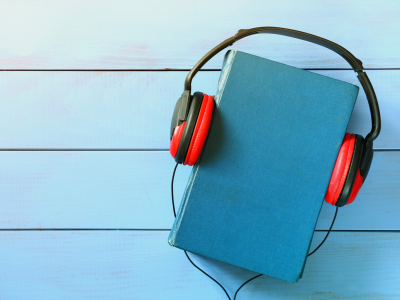 Blue book with orange headphones placed on it