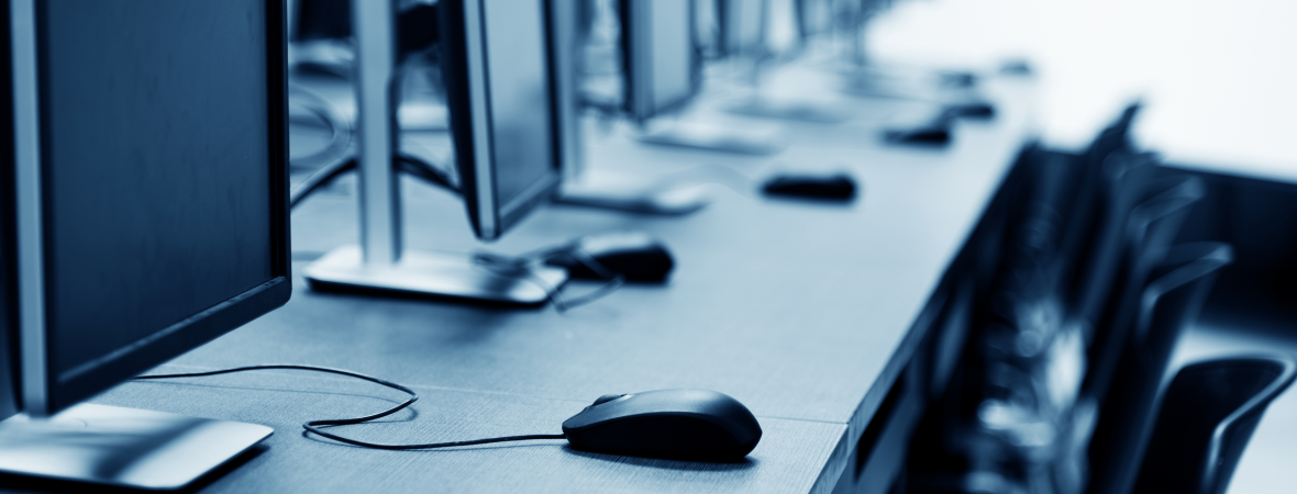 Desk with row of computers and mice